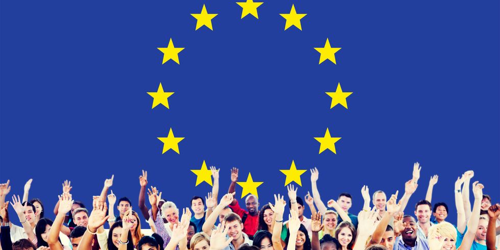 diverse Menschen heben die Hand vor EU-Flagge