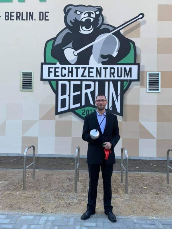 Michael Behrendt, 1. Vorsitzender des Fechtsportzentrums Berlin e.V vor der neuen Halle mit dem Logo