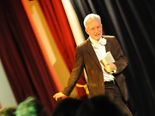 Mann mit Mikrophon auf einer Bühne im Tschechow Theater