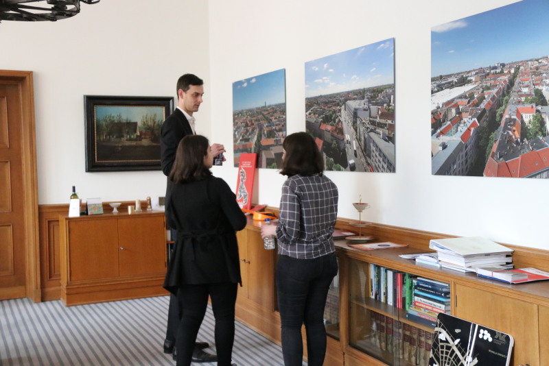 Gemeinsam betrachten der Bürgermeister und die beiden Schülerinnen Panaoramaaufnahmen Neuköllns im Büro.