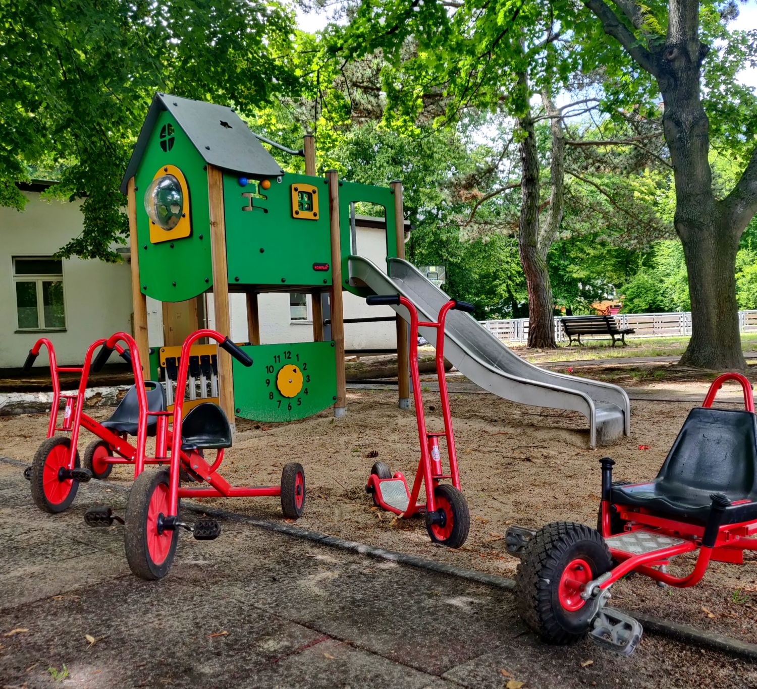 Fahr- und Spielgeräte auf dem Spielplatz vorm Haus am See 