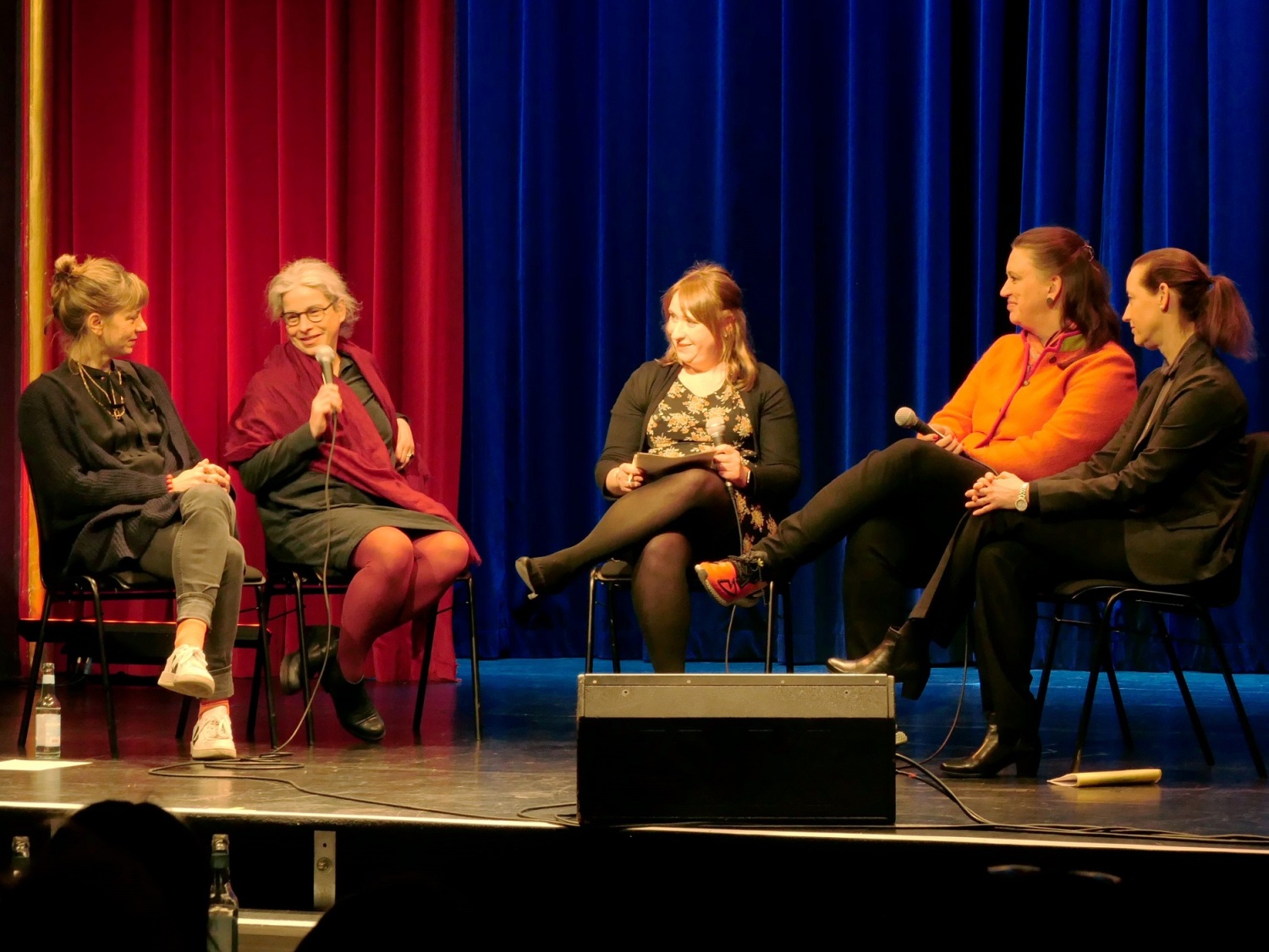 Fünf Frauen sitzen im Halbkreis auf Podium im Gespräch