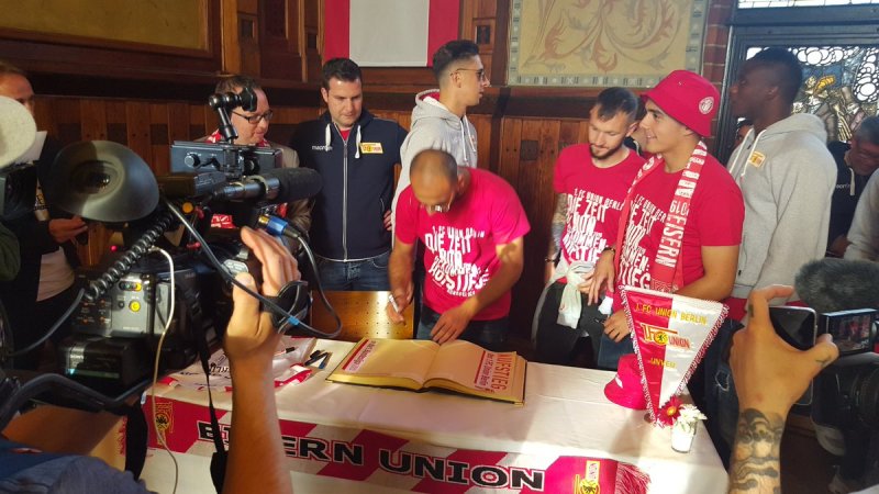 Die Mannschaft des 1. FC Union Berlin trägt sich ins Goldene Buch des Bezirks ein