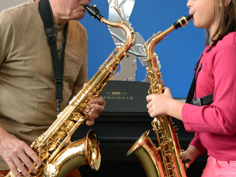 78-Jähriger und 8-Jährige üben am Saxophon