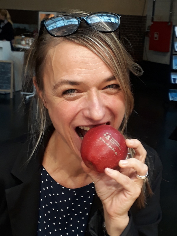 Frau beißt in einen Apfel mit dem EA Logo