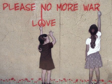 Zwei kleine Mädchen schreiben und malen Anti-Kriegs-Parolen an die Wand.
