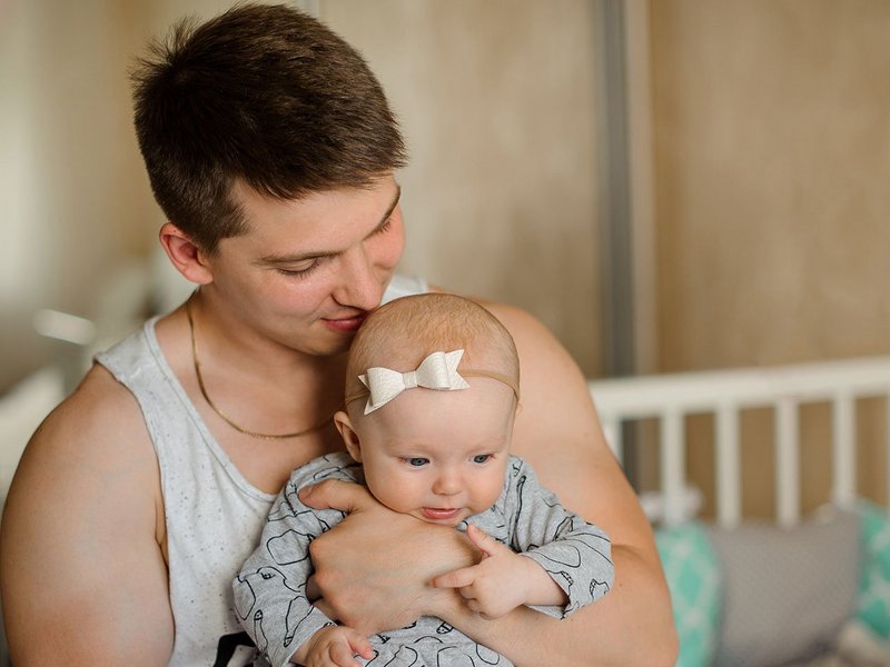 Junger Vater hält ein Baby auf dem Arm