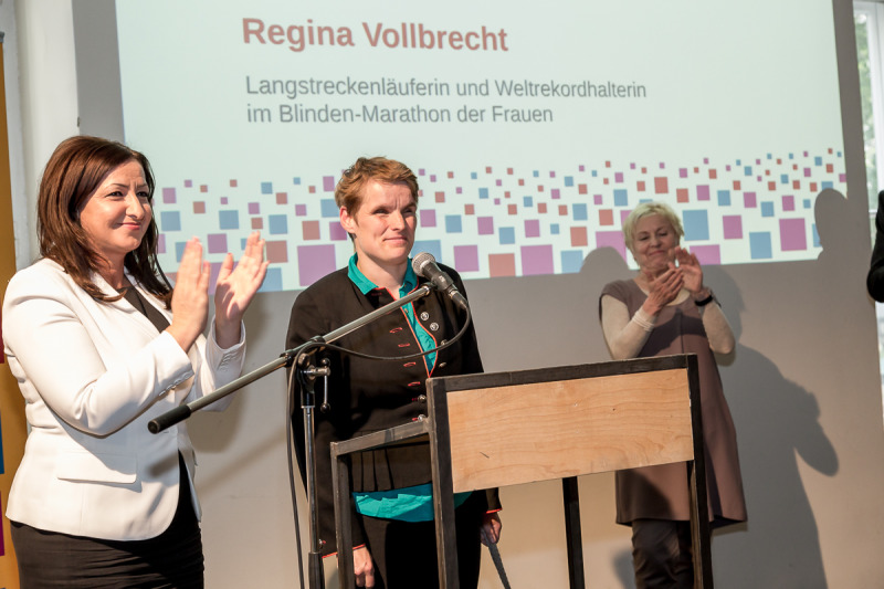 Regina Vollbracht hält ihre Rede, daneben zu ihrer linken Dilek Kolat, auf der rechten Seite Bascha Mika