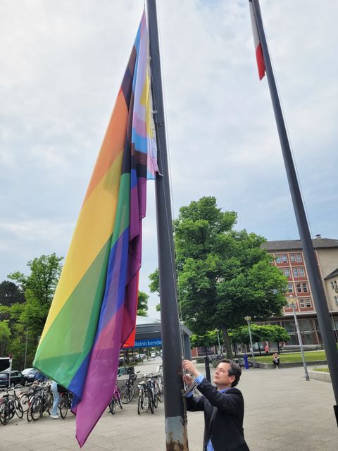 Bezirksbürgermeister Uwe Brockhausen hisst die "Progress-Pride-Flagge". (Bild: BA Reinickendorf)