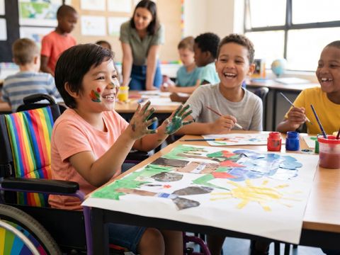 Kunstunterricht in Grundschule dabei sitzt ein Schüler im Rollstuhl
