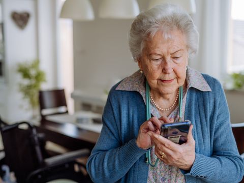 Ältere Frau schaut auf ihr Handy