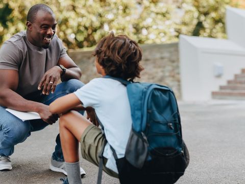 Lehrer unterhält sich mit jungen Schüler auf dem Schulgelände