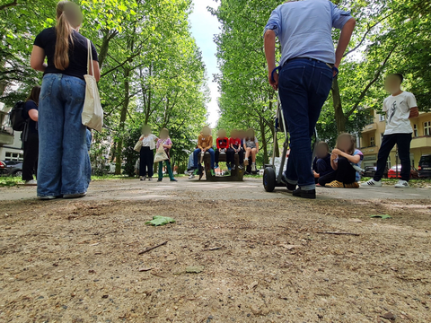 Schillerpromenade mit Teilnehmenden der Kiez-Schatzsuche, Kinder auf Tischtennisplatte, verwischte Gesichter
