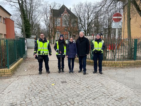 Bezirksstadträtin für Ordnungsangelegenheiten Julia Schrod-Thiel (Mitte) und Bezirksstadtrat für Schule und Sport Harald Muschner (2.v.r.) mit Mitarbeitenden des Verkehrsüberwachungsdienstes vor der Marc-Twain-Schule (Bild: BA Reinickendorf)