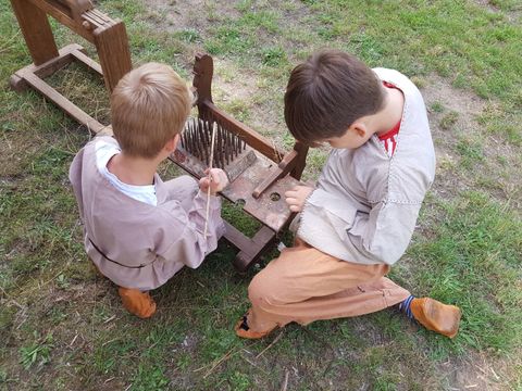 Kinder verarbeiten Flachs auf dem germanischen Gehöft (Bild: Claudia Wasow-Kania Museum Reinickendorf)