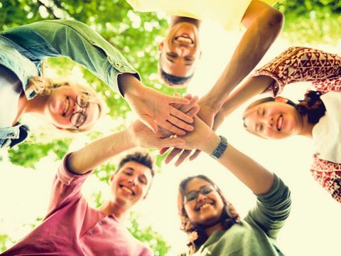 Lachende Menschen reichen sich die Hände