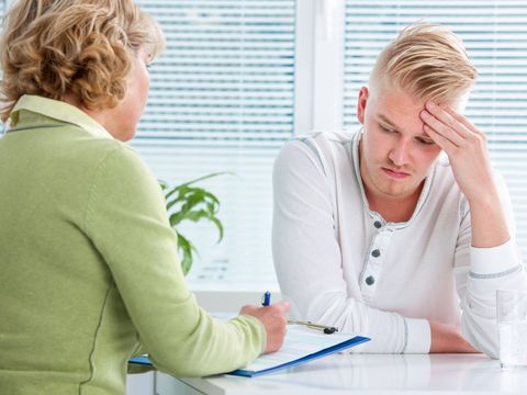 Eine Psychotherapeutin berät einen Patienten in ihrer Praxis