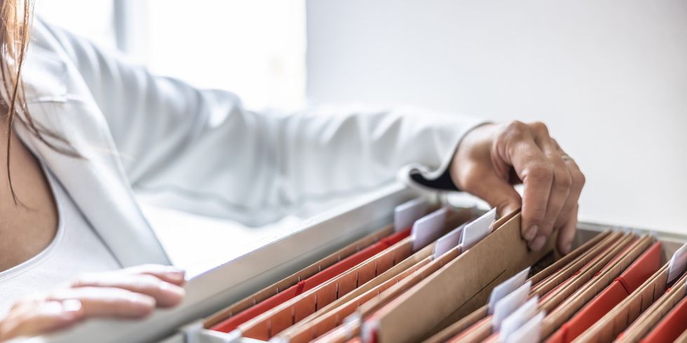 Eine Frau sucht eine Akte im Aktenschrank