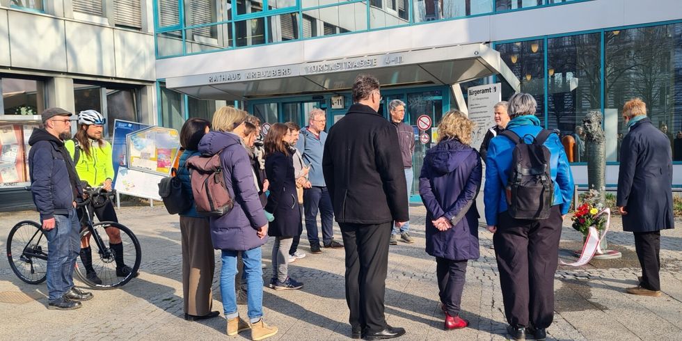 Die stellvertretende Bezirksbürgermeisterin Regine Sommer-Wetter und Andy Hehmke, Bezirksstadtrat für Schule, Sport und Facility Management, vor dem ehemaligen Rathaus Kreuzberg Blumen nieder