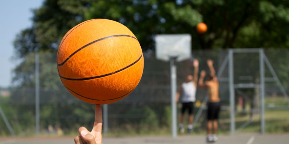 Basketball im Vordergrund auf einem Finger drehen
