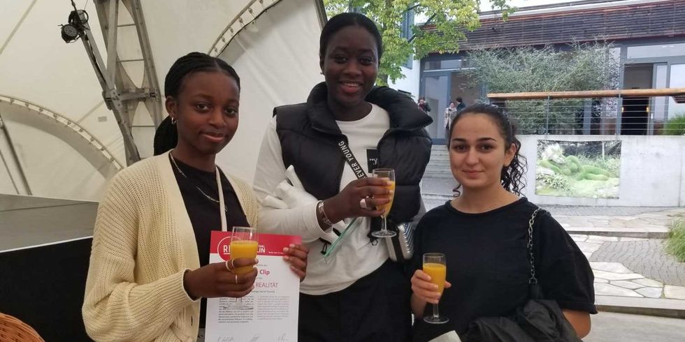 Drei fröhliche junge Frauen mit einer Urkunde