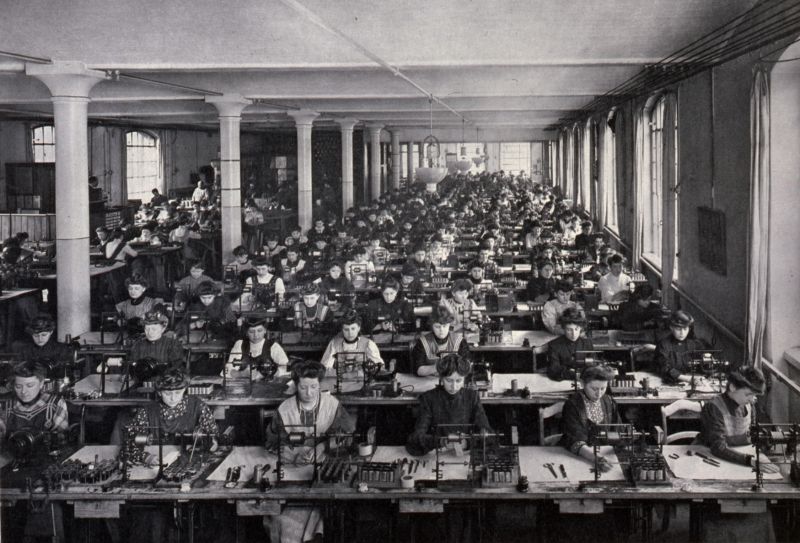 Gruppenbild schwarz-weiß von arbeitenden Frauen in einer Werkhalle mit Spulen wickeln