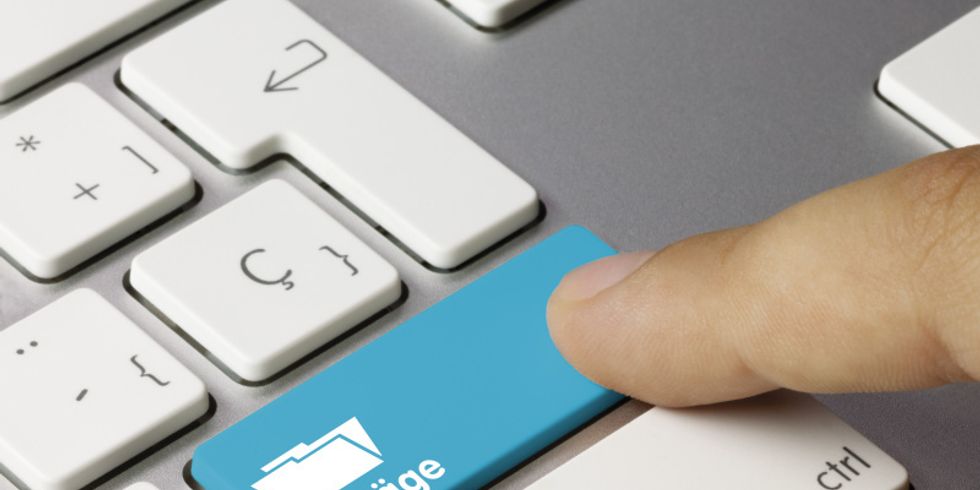 Ausschnitt einer Tastatur mit einer blau hervorgehobeben Taste auf der Anträge steht und von einem Finger berührt wird