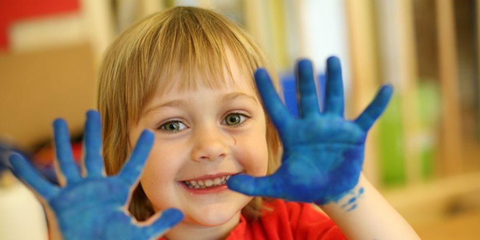 Mädchen hat blaue Hände vom Malen