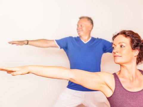 Frau und Mann beim Yoga - Krieger