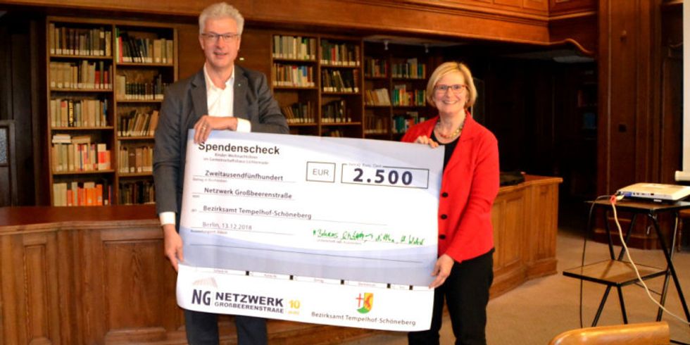 Der Vorstandsvorsitzende Hinrik Weber übergibt den Spendenscheck an Bezirksbürgermeisterin Angelika Schöttler 