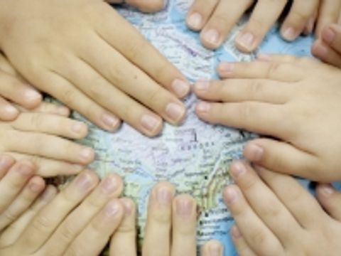 Kinderhände auf Globus - Globales Lernen