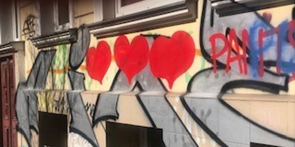 Graffiti mit drei Herzen an einer Häuserwand in der Rheinsberger Straße