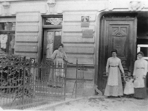 Historische Aufnahme von Frauen und Kindern vor einem Haus