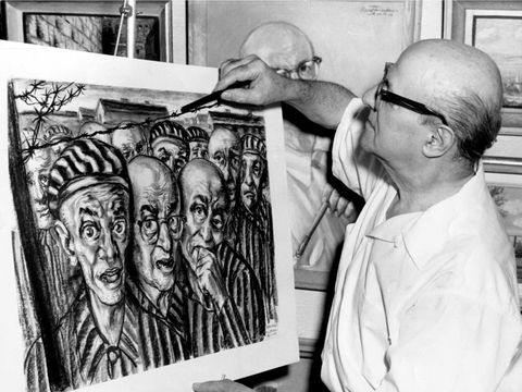 David Friedmann adds final touches to his charcoal drawing, “Liberation?” The artist depicts himself as the prisoner with eyeglasses