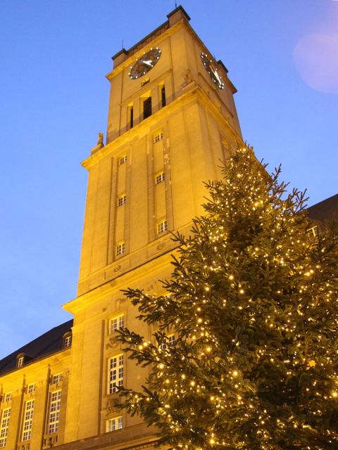 Beleuchteter Weihnachtsbaum, der vor dem Rathaus Schöneberg steht.