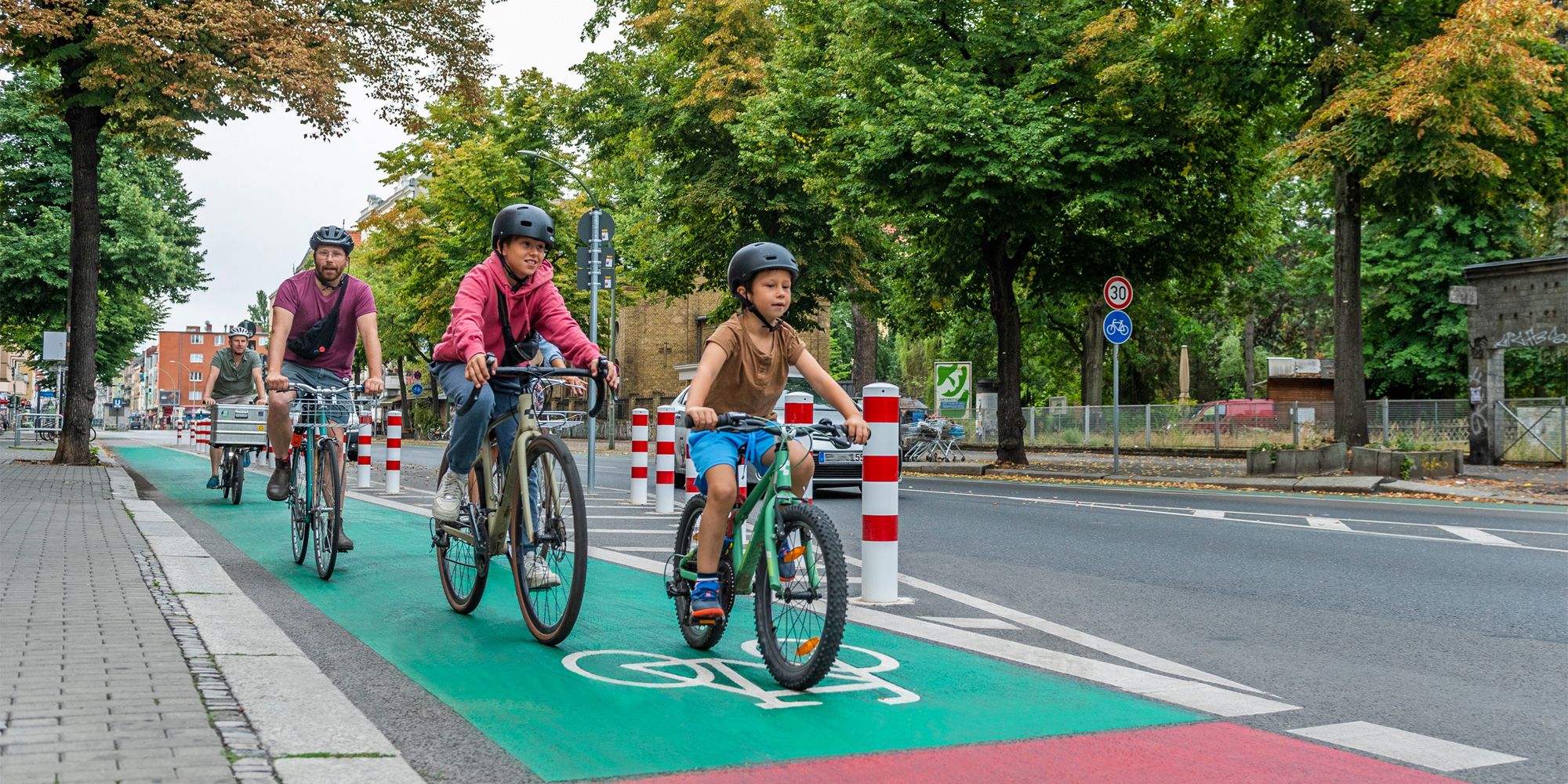 Radfahrende Kinder auf grünbeschichtetem Radweg in der Hermannstraße