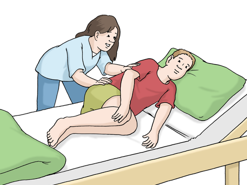 Eine Pflege-Kraft betreut eine Person im Bett