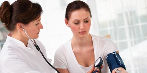 Ärztin misst den Blutdruck und Puls bei Patientin