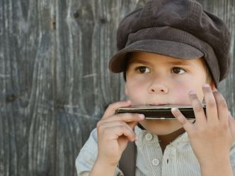 Bildvergrößerung: Junge spielt auf der Mundharmonika