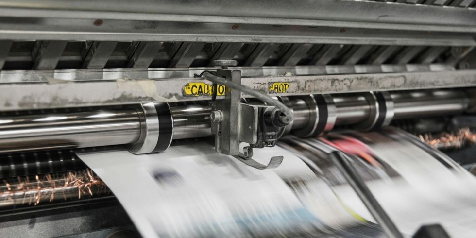 Druckerpresse, aus der Zeitungen kommen 