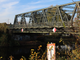 Aufnahme der Späthstraßenbrücke in Neukölln mit Uferanschnitt, Schifffahrtsschild und Zweige im Vordergrund
