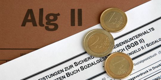 Euro-Münzen liegen auf einem Alg-II-Antrag