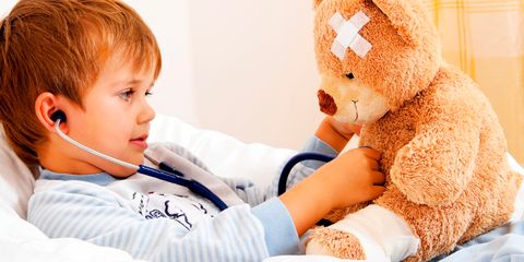 Krankes Kind untersucht Teddy mit Stethoskop