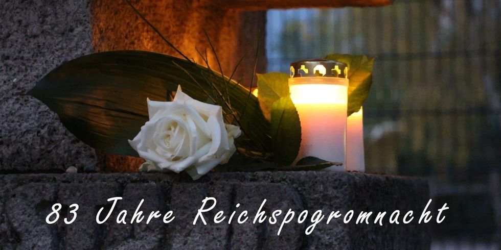 Weiße Rose mit Kerze und dem Schriftzug 83 Jahre Reichspogromnacht