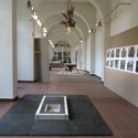 Bildvergrößerung: Blick in die Ausstellung mit zusätzlichen Wänden aus Spanplatten die an die Wände der Galerie angelehnt sind