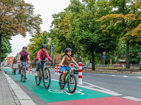 Radfahrende Kinder auf grünbeschichtetem Radweg in der Hermannstraße