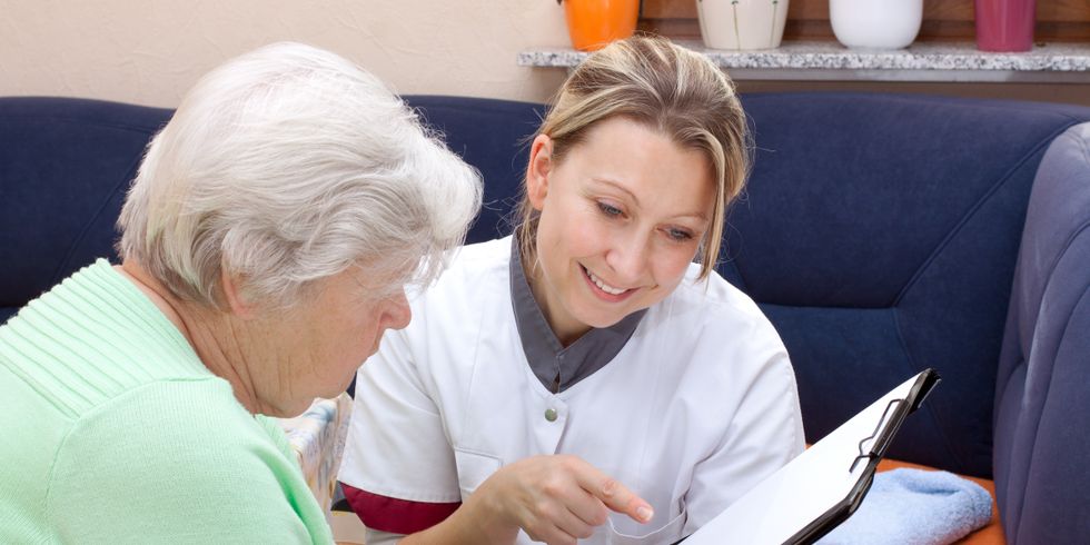 Altenpflegerin erklärt Seniorin ein Formular