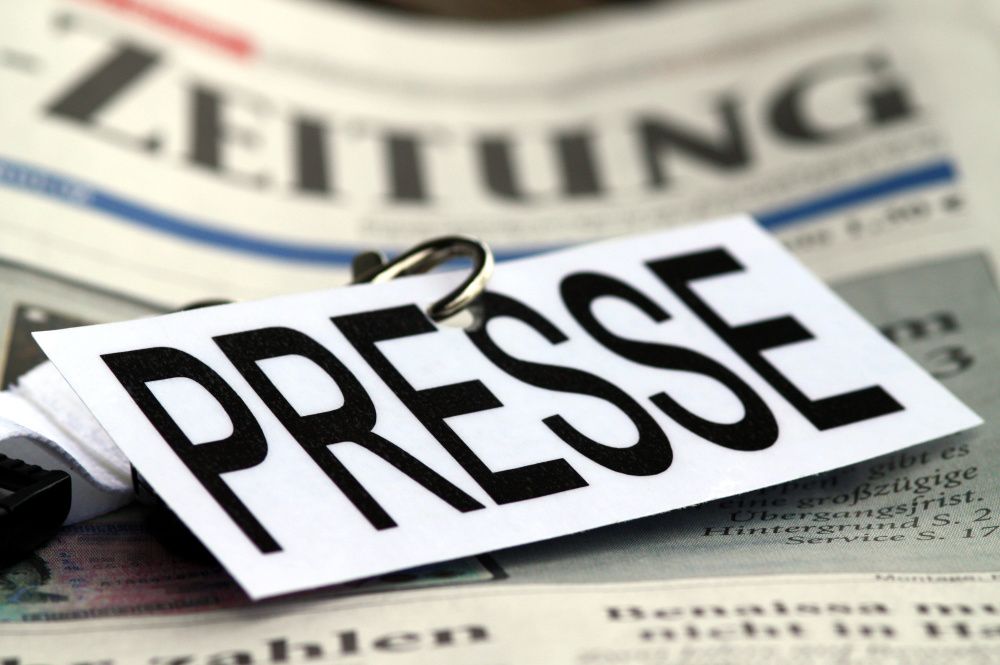 Ein Schild mit der Aufschrift "Presse" liegt auf einer Tageszeitung