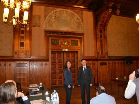 Bildvergrößerung: Bezirksbürgermeister Oliver Igel und die beauftragte Restauratorin Anette Schulz beim Pressegespräch zu den Leinwänden im Ratssaal