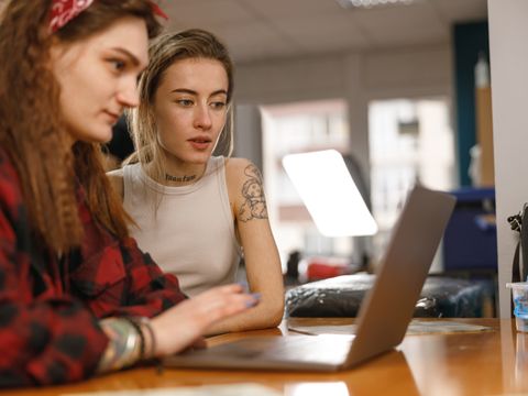 Zwei junge Frauen sitzen am Laptop